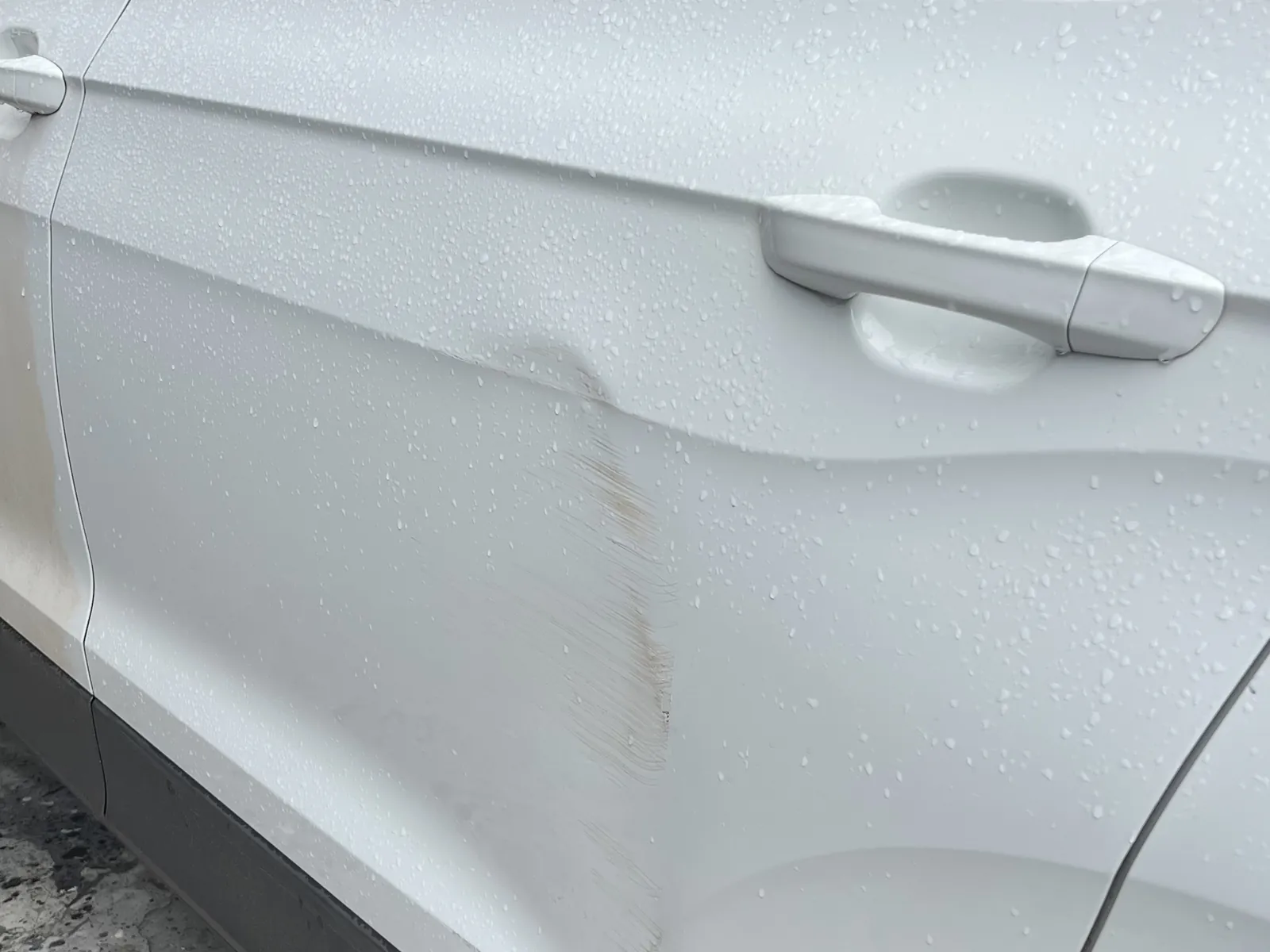Amassado na porta traseira de um VW T-Cross branco, candidato a martelinho de ouro