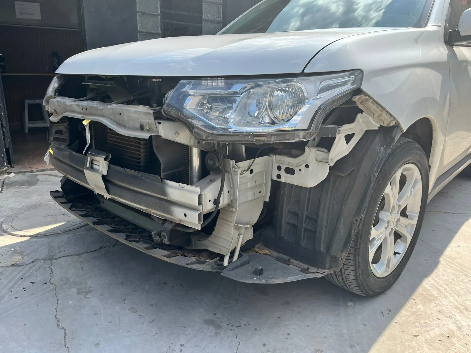 Mitsubishi Outlander com a frente destruída chegando para lanternagem na Replikar