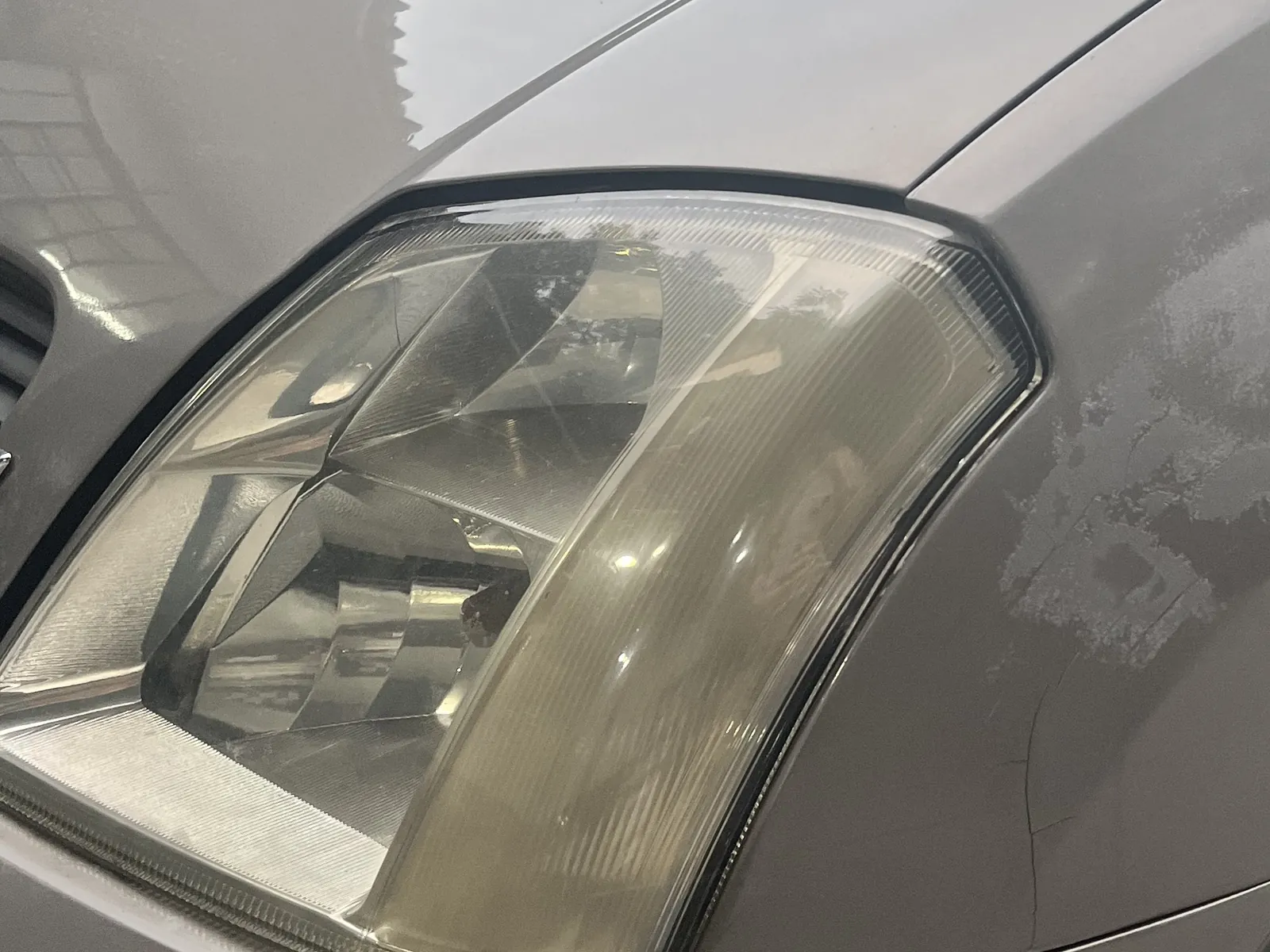 Farol amarelado e opaco de um Chevrolet Meriva antes do polimento