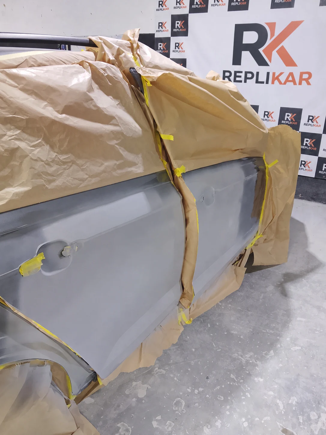 Portas de um VW Nivus com fundo aplicado e o carro mascarado para pintura na Replikar