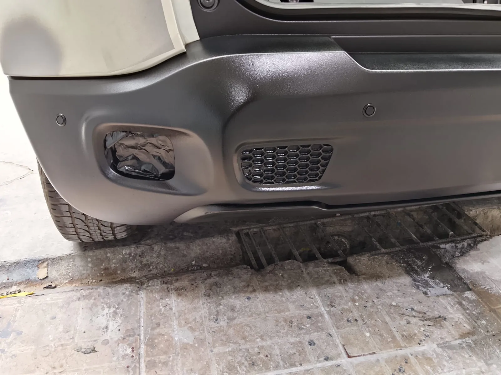 Para-choque traseiro de Jeep Renegade danificado, com o farol de neblina arrancado, antes do reparo